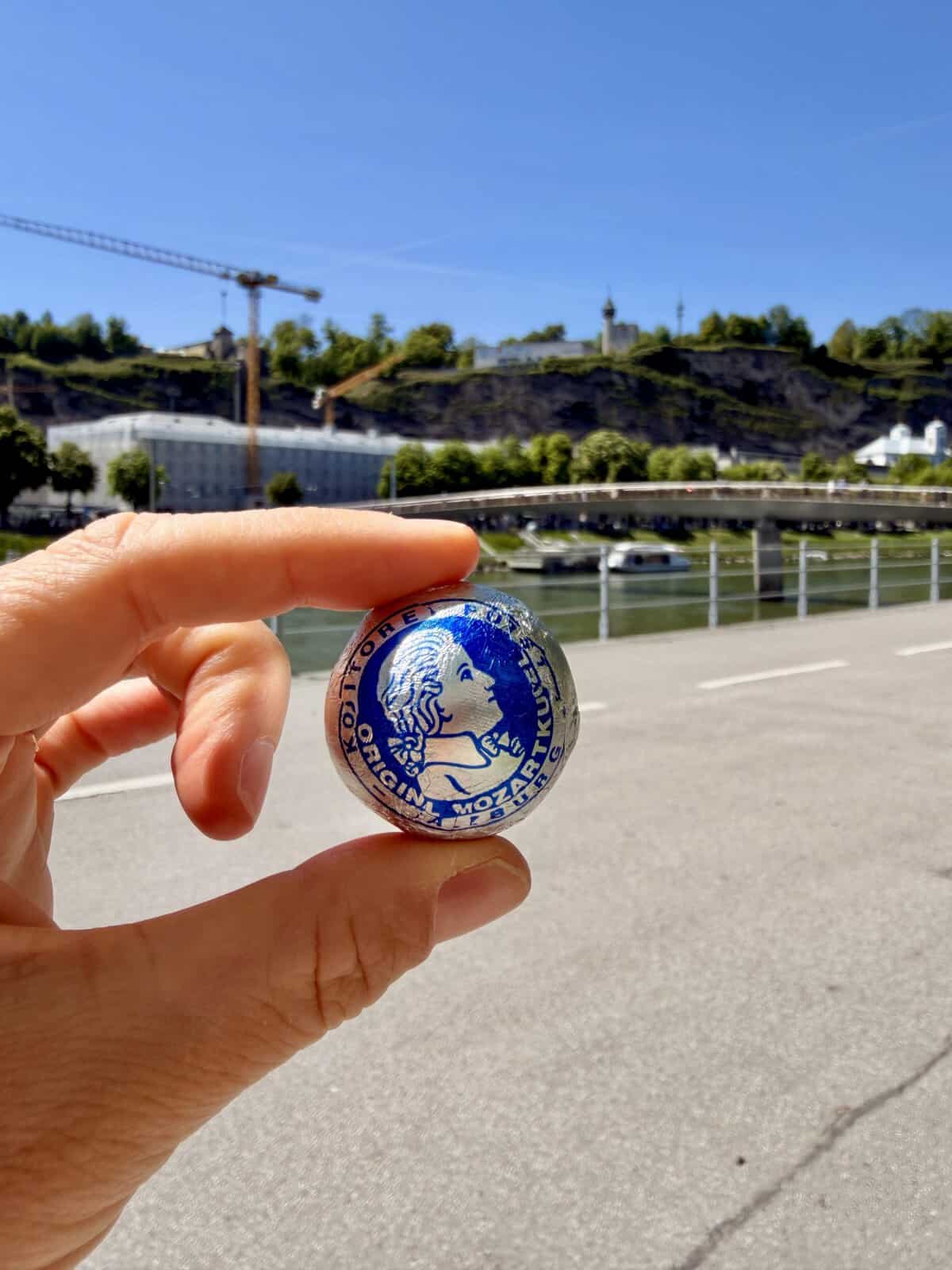 Hand holding an Original Salzburger Mozartkugel chocolate in Salzburg, Austria.