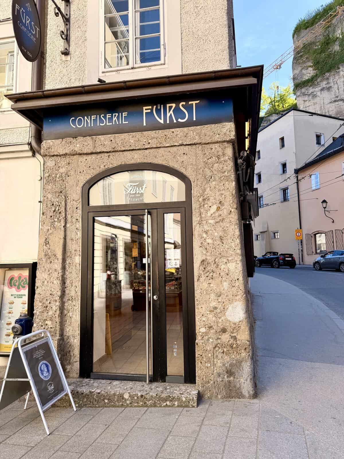 The entrance to Confiserie Fürst in Salzburg, a historic confectionery on a narrow Old Town street and a popular stop for trying Mozartkugeln during a Salzburg itinerary.