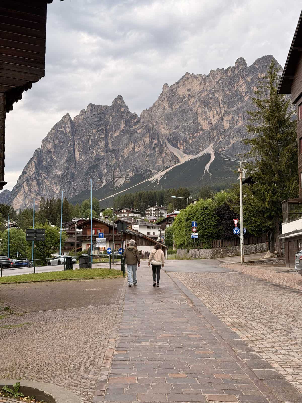 Street in Cortina d’Ampezzo with dramatic Dolomites mountain views, a popular base for visiting Tre Cime di Lavaredo