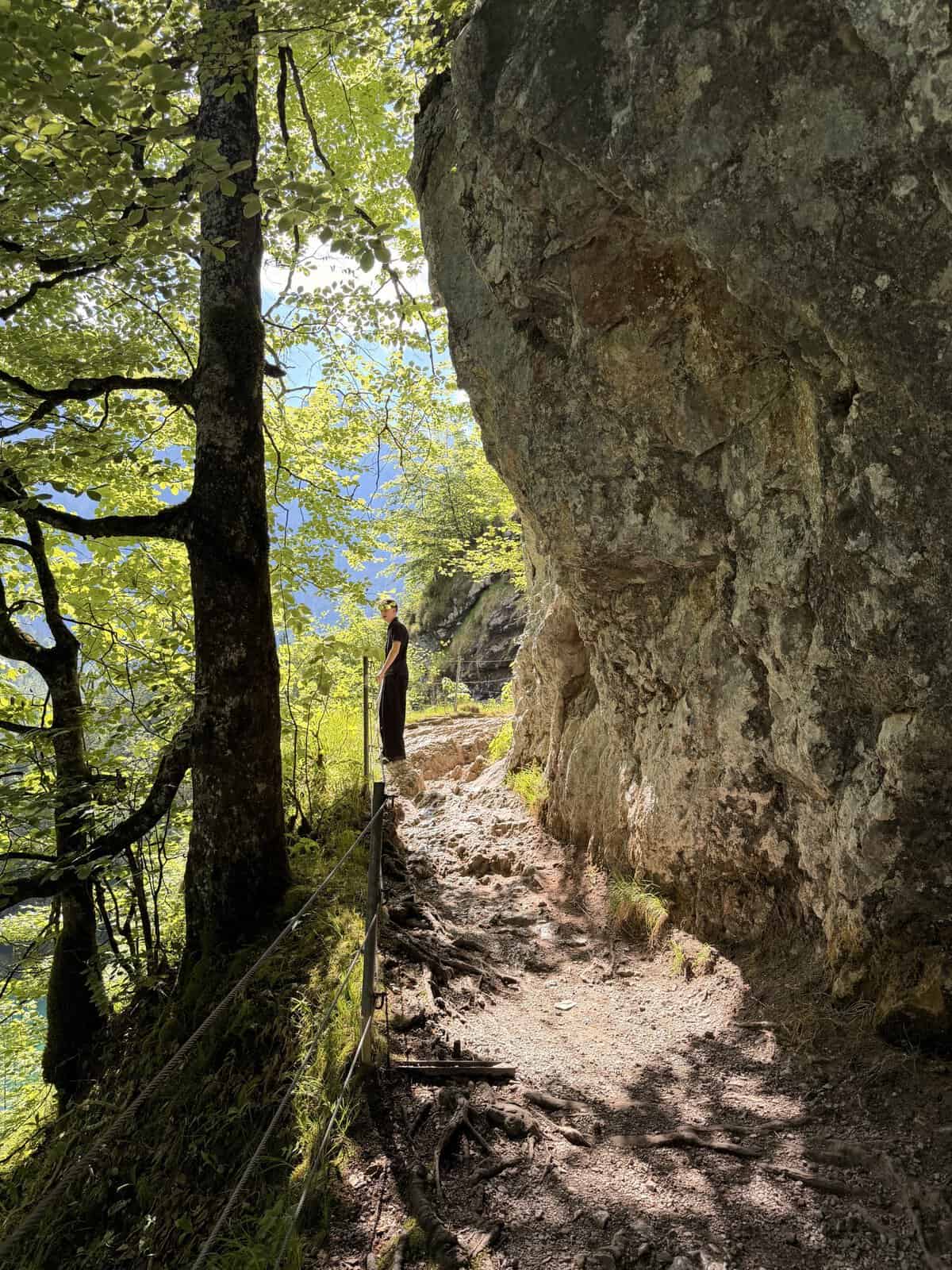 Rocky hiking trail beneath a cliff beside Obersee near Lake Königssee in Berchtesgaden