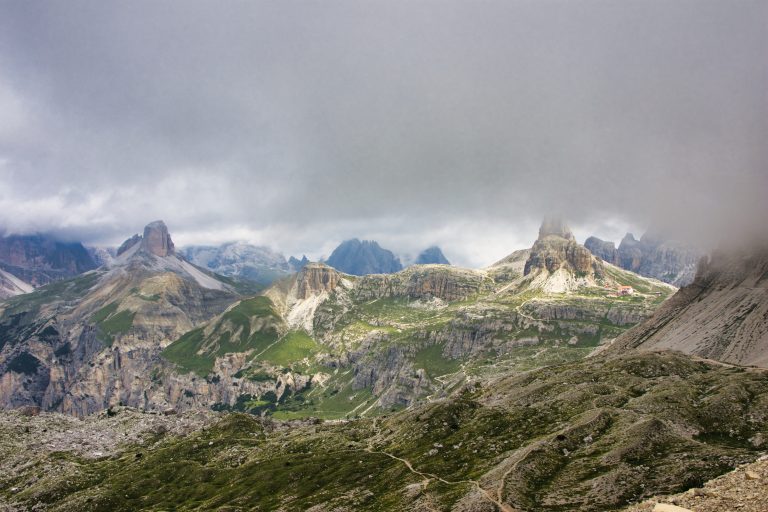 Cloud-covered mountain peaks, hiking trails and a remote refuge in the Dolomites, Italy