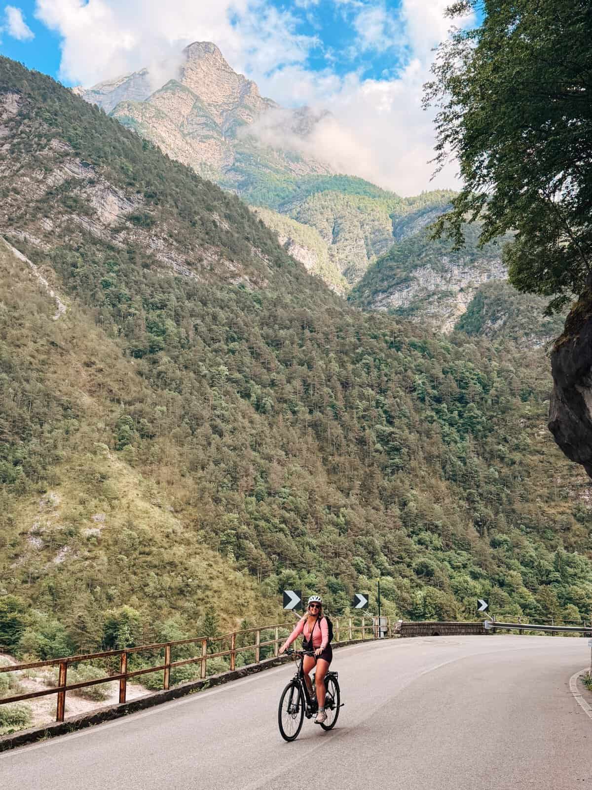 Women cycling in Italy, surrounded by majestic mountains.