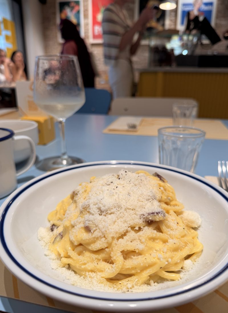 Pasta Carbonara in Italy, with parmiggiano on top.