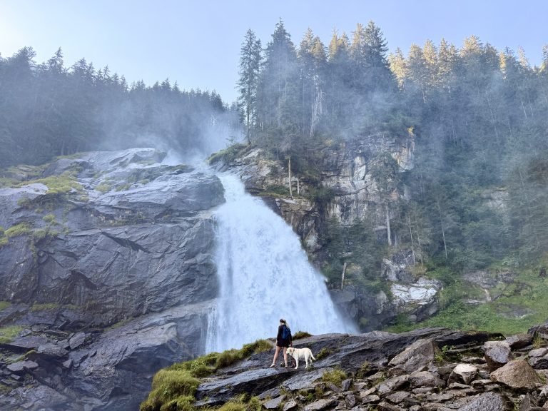 First-tier of the Krimml Falls in Austria. Massive waterfall and a women and her dog shows how huge the waterfall is.